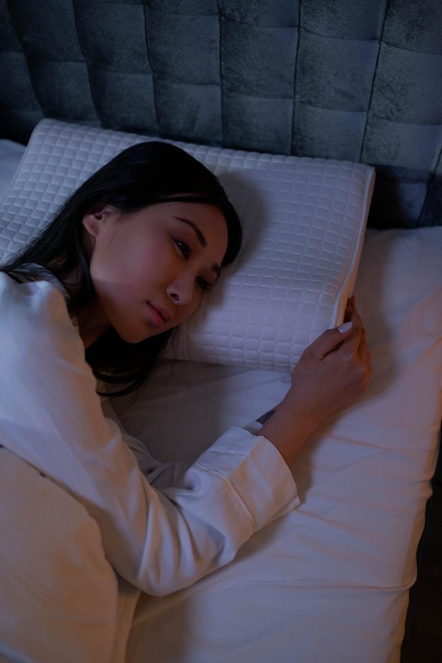 woman in white long sleeve shirt lying on bed